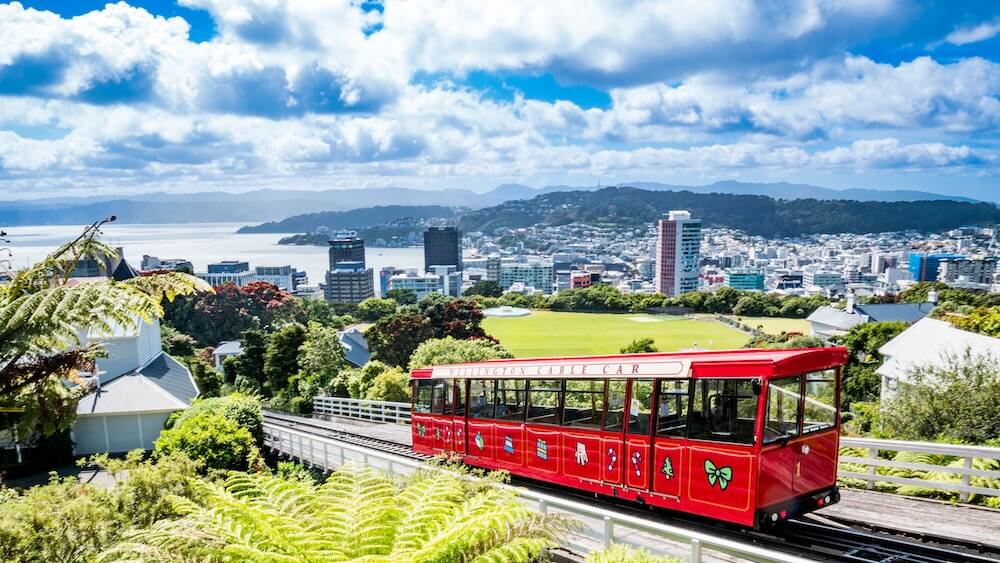 Wellington cable car on a backdrop of sunny Wellington city.